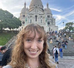 woman taking photo in front of ornate buildings