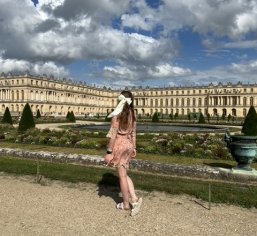woman in front of palatial building